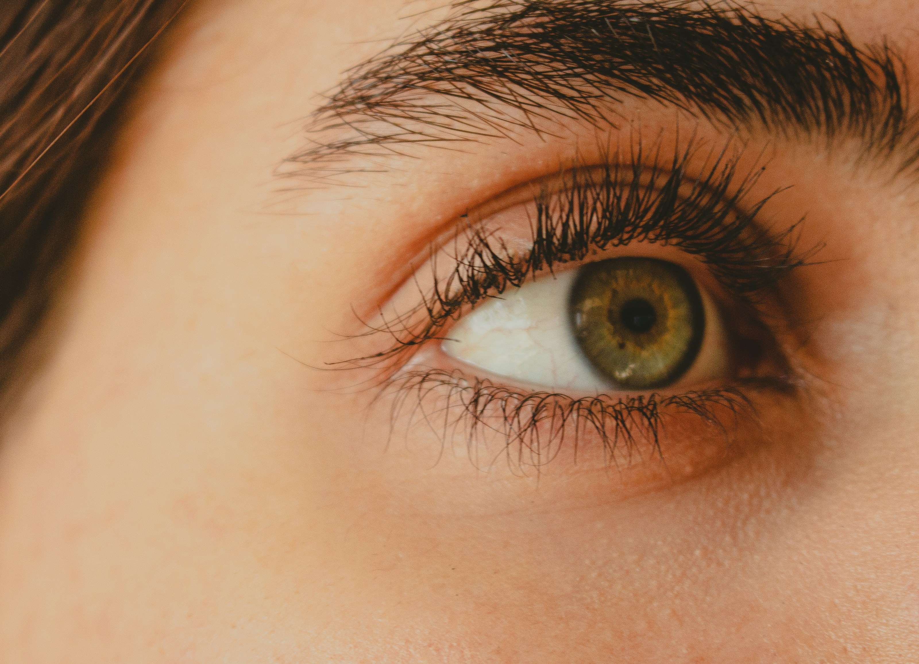 Nahaufnahme eines grünen Auges mit Wimpernverlängerung im Beauty Atelier Isabelle in München-Pasing